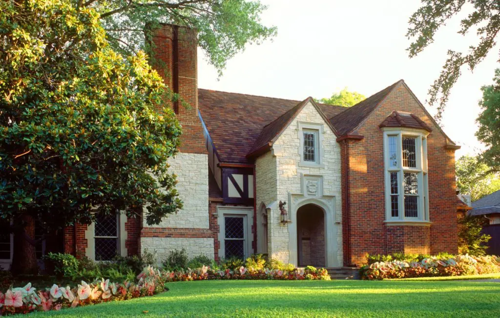 A large brick house with a lawn in front of it.