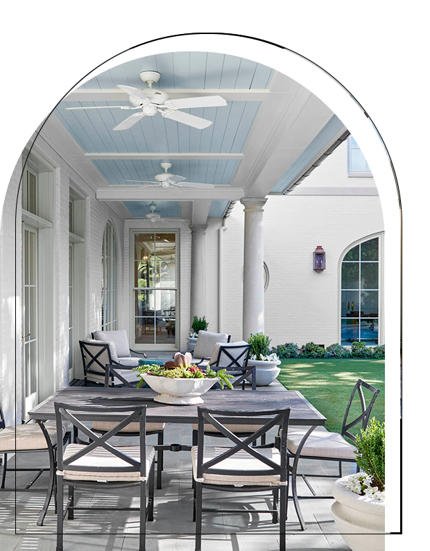 A patio with a table and chairs, and a bowl of fruit.